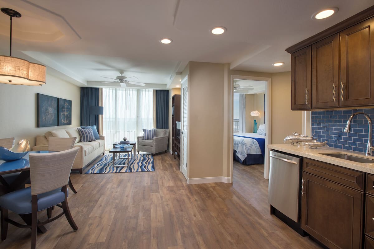 A modern kitchen with wooden cabinets, a dishwasher, and a countertop with decorative items.
