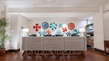 Un mostrador de recepción de diseño moderno, rodeado de piso de madera y paredes blancas.