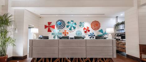 A reception desk with a modern design, surrounded by a wooden floor and white walls.