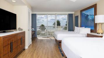 A hotel room with a balcony, a television, two beds, and a painting.