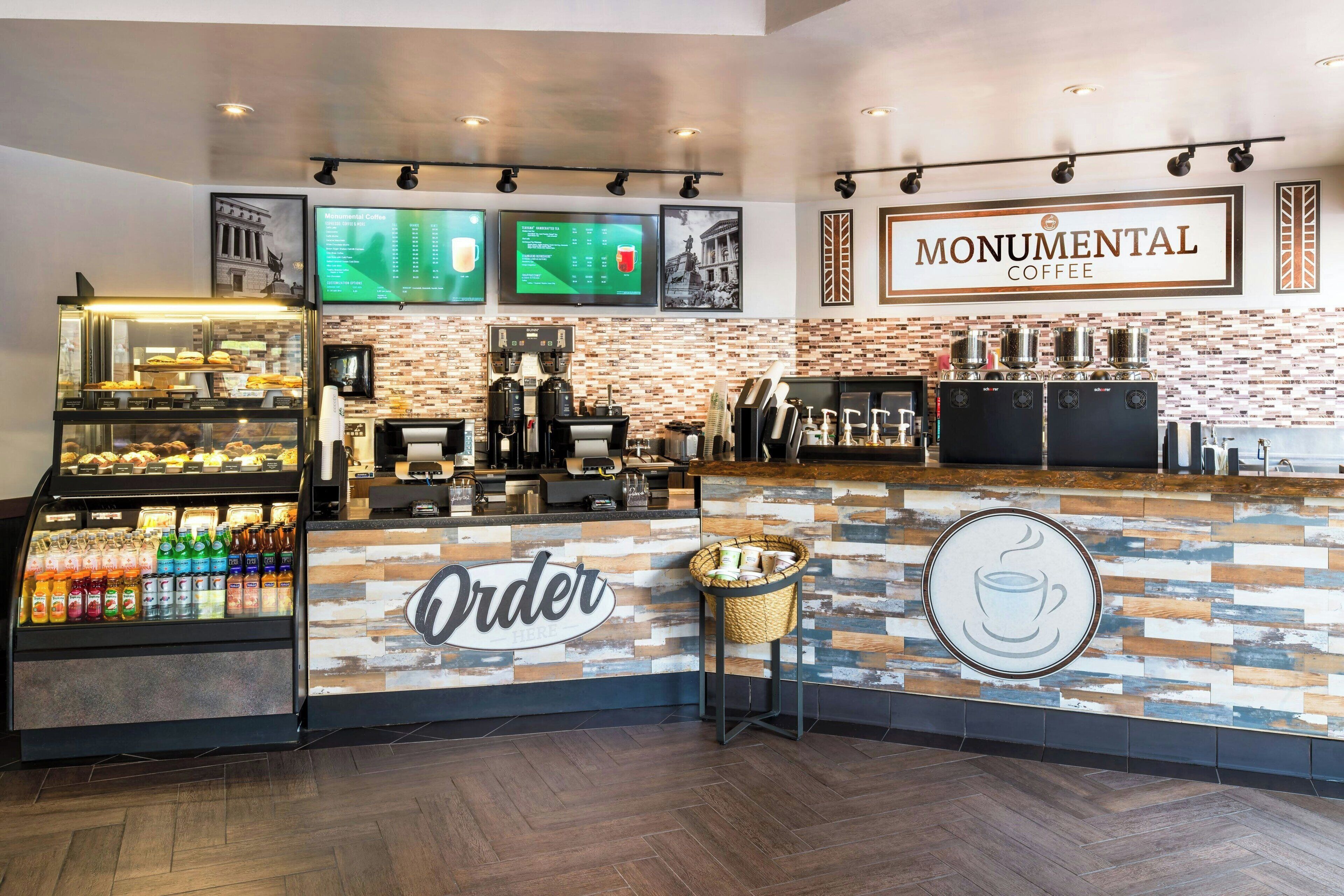 A coffee shop interior with a counter, menu boards, and a beverage display.