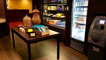 A self-service beverage station with a refrigerated drink dispenser and a snack display.