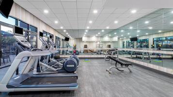 Ett modernt gym med löpband, crosstrainers och styrketräningsutrustning.
