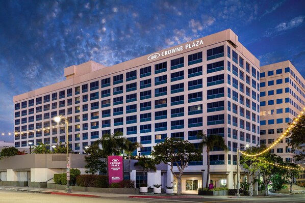 Un hotel de varios pisos con diseño moderno, que destaca la señalización de Crowne Plaza.