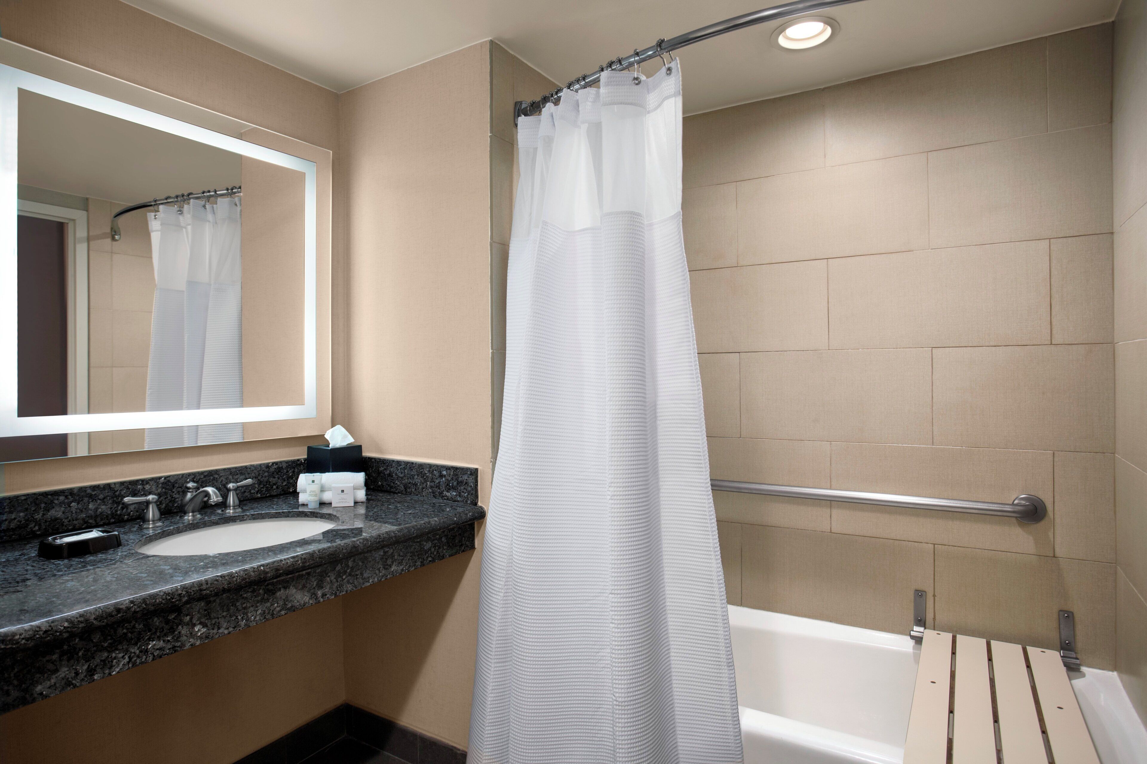 A bathroom with a shower curtain, a sink, and a bathtub.