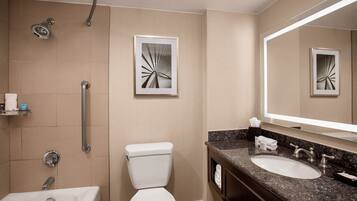 Een moderne badkamer met douche, toilet en wastafel.