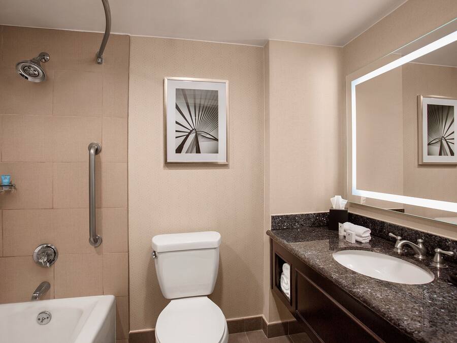 Een moderne badkamer met douche, toilet en wastafel.