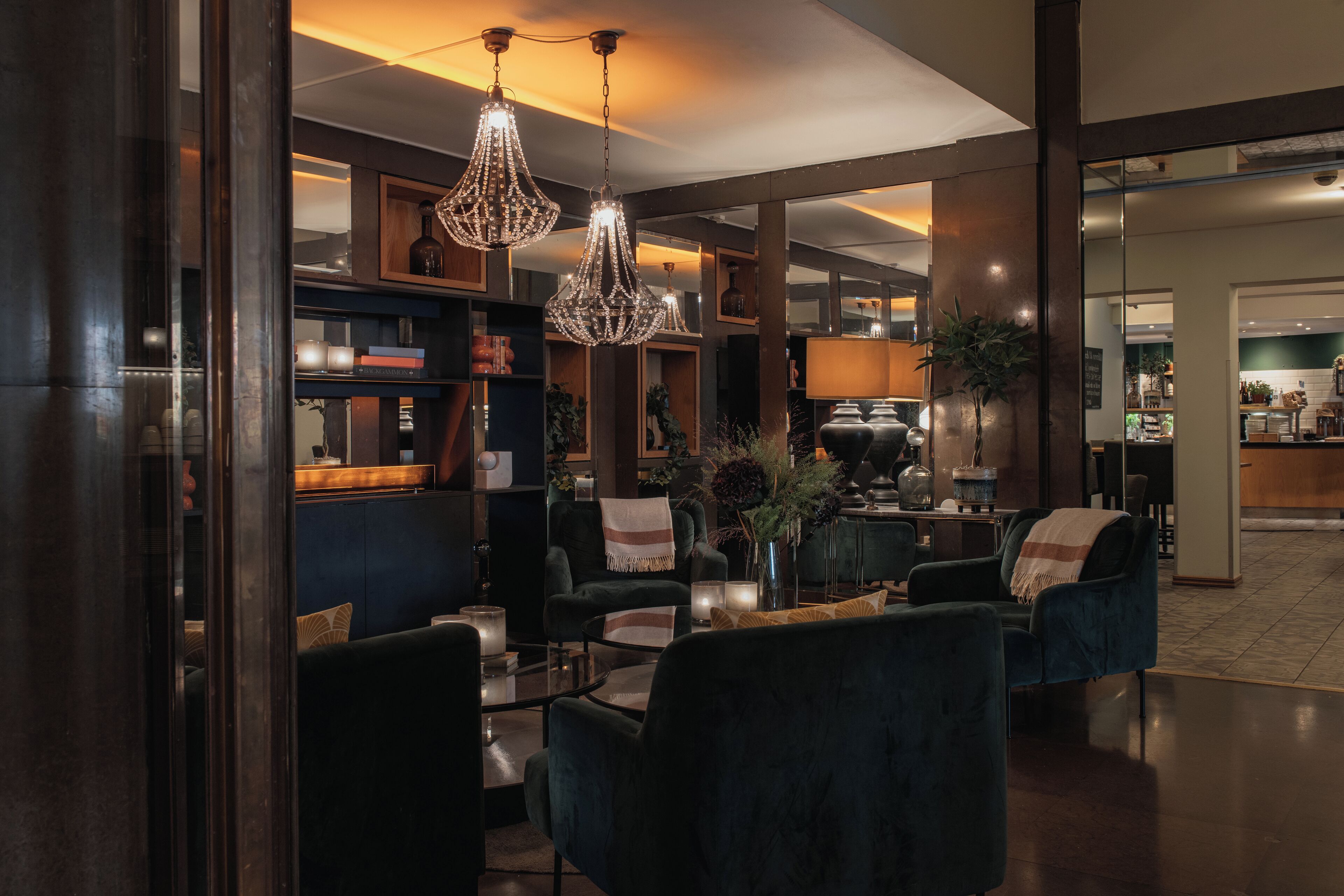 A modern interior with dark-toned furniture, a bar area, and decorative lighting.