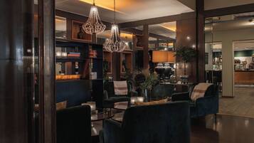 A modern interior with dark-toned furniture, a bar area, and decorative lighting.