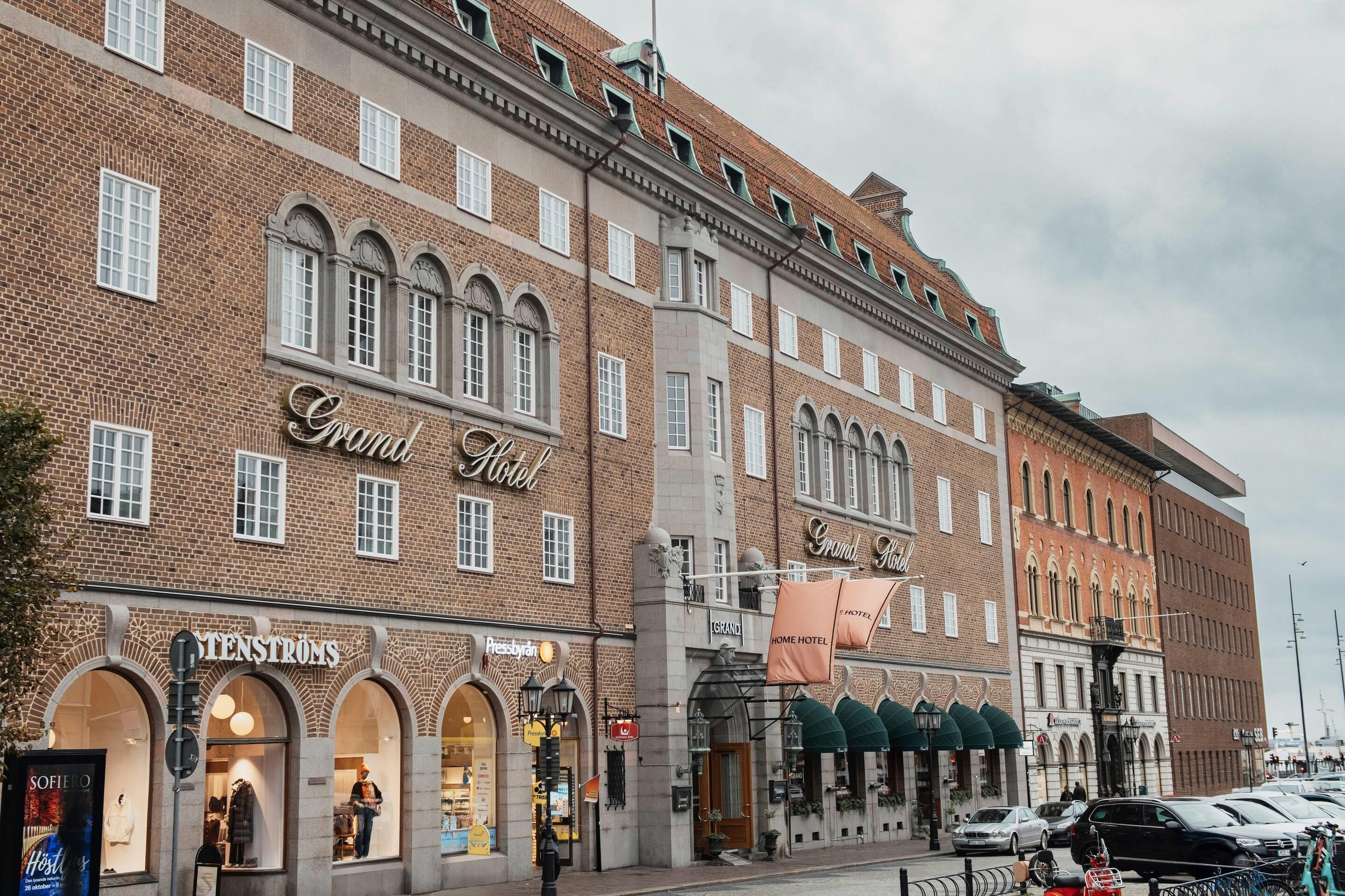 A historic building with the Grand Hotel sign, featuring arched windows and a brick facade.