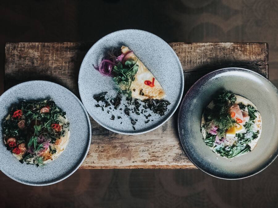 Tres platos de comida sobre una tabla de madera.