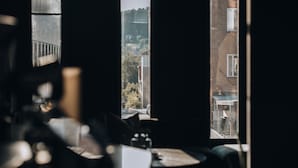 A room with a large window, a chair, and a table.