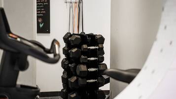 A stack of black dumbbells in a gym setting.