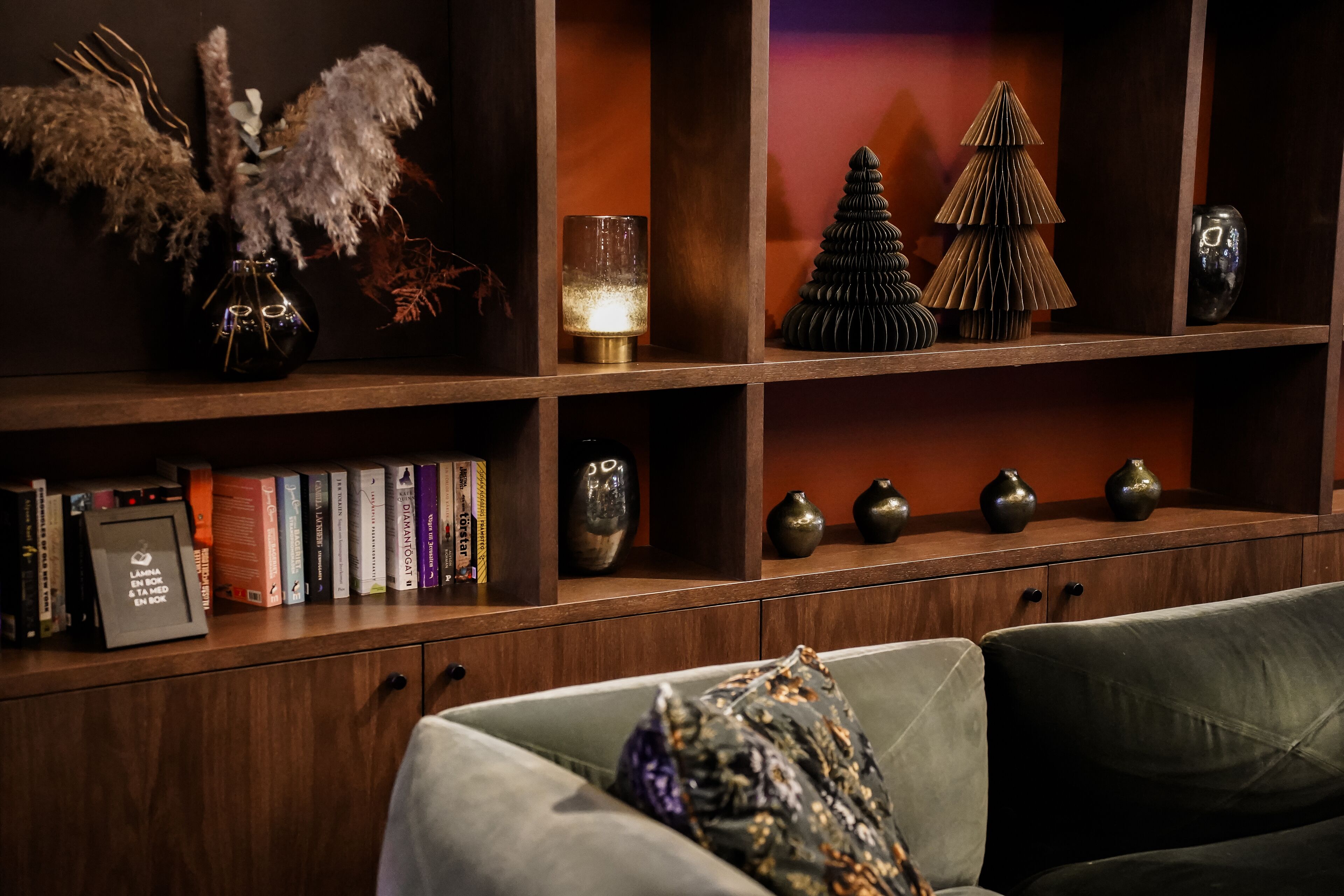A cozy living area with a bookshelf, decorative items, and a comfortable sofa.