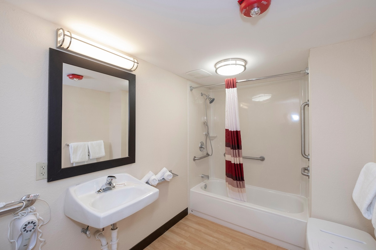 A bathroom with a sink, mirror, shower, and toilet.