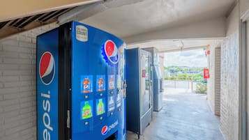 A vending machine with a Pepsi logo, a sign indicating calorie count, and various beverage options.