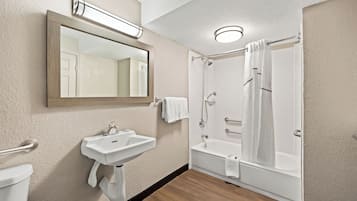 A bathroom with a sink, mirror, and shower.