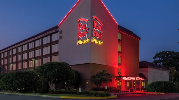A building with a distinctive red roof and illuminated signage reading 'Red Roof Plus'. - Red Roof Inn PLUS+ Boston - Woburn/ Burlington (Woburn)