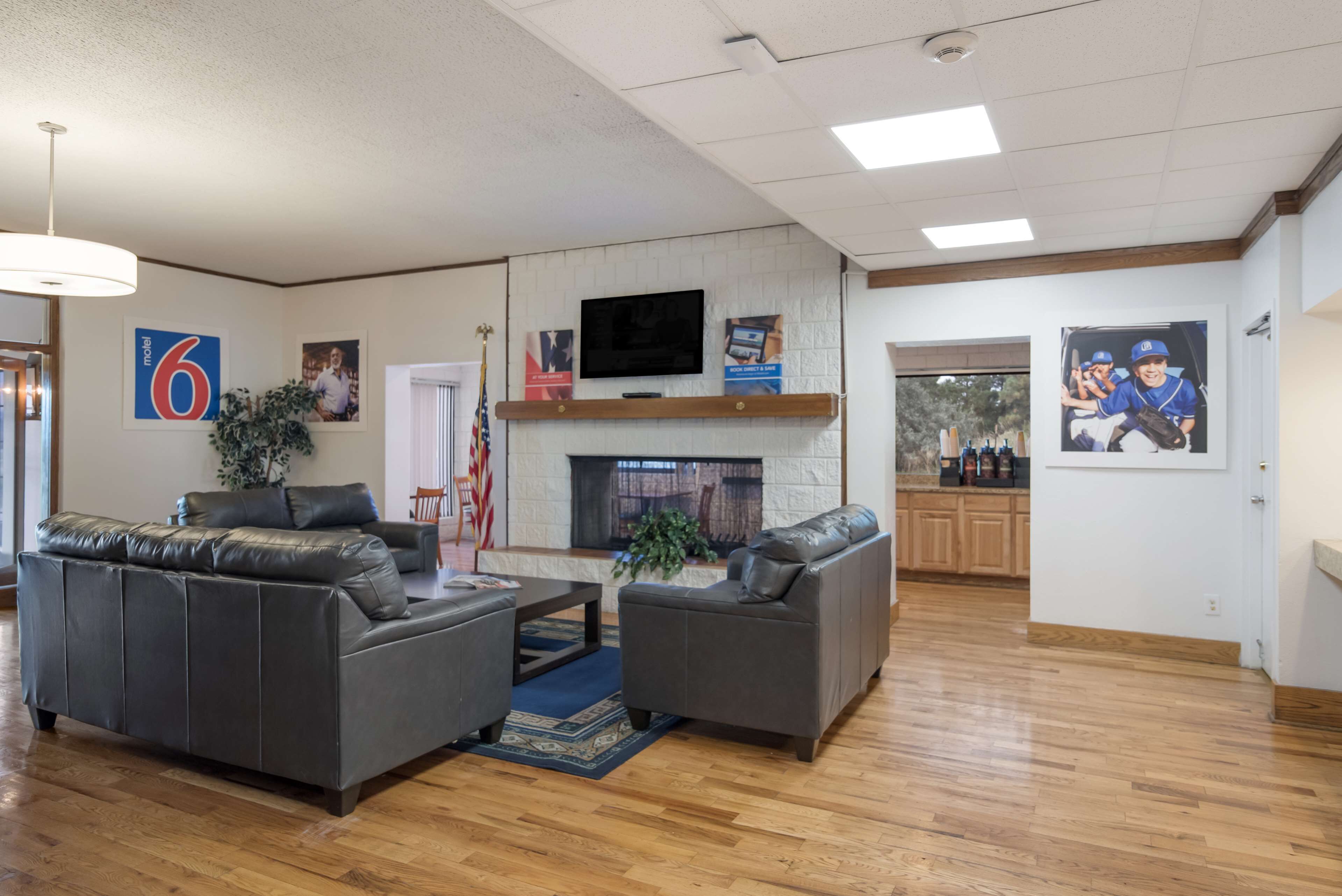 A spacious living room with a fireplace, leather sofas, and a television mounted on the wall.