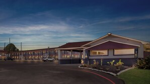 A motel with a central building and a row of attached units. - Econo Lodge Inn & Suites Sealy (Sealy)