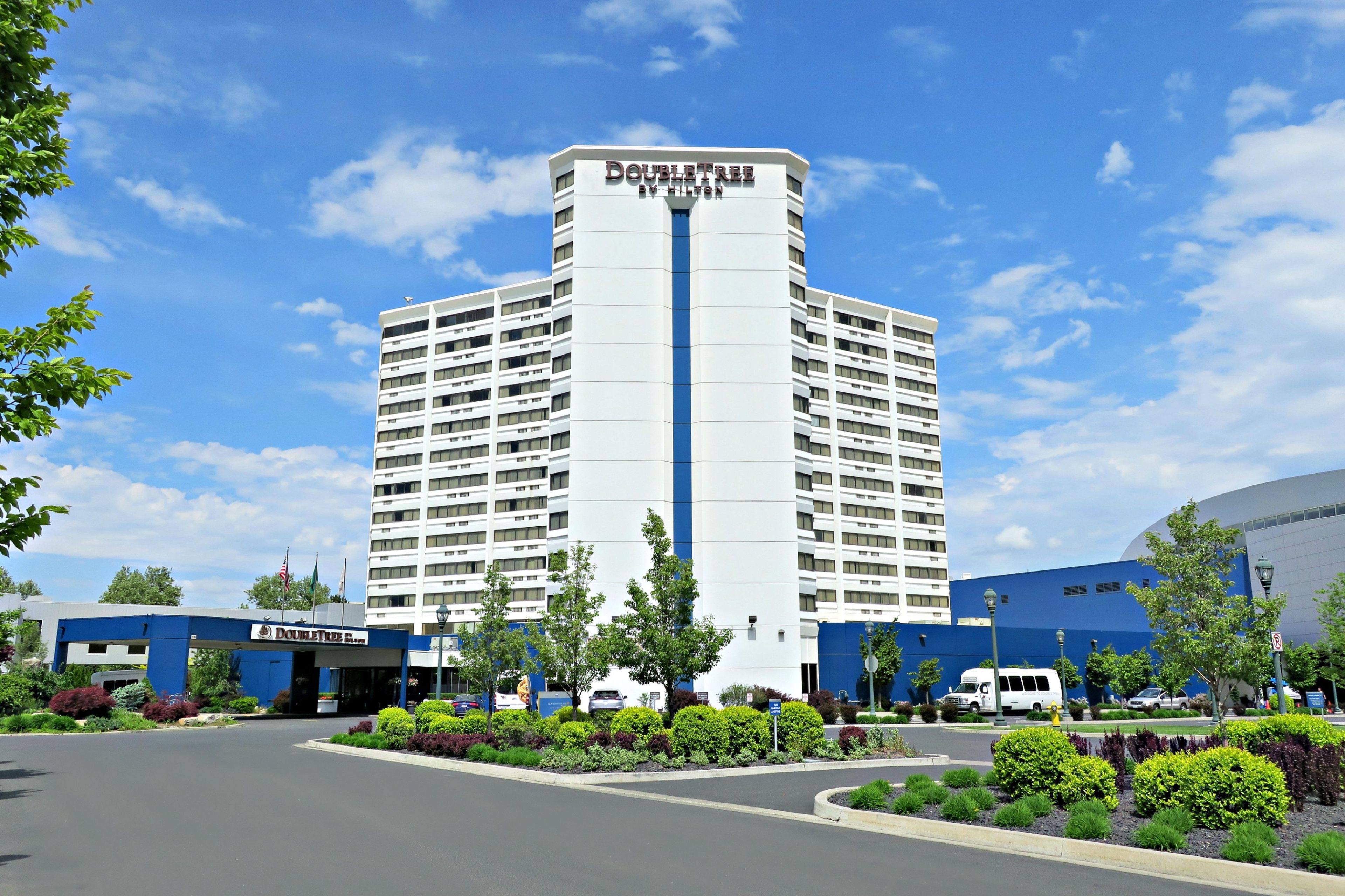 A hotel with a central tower and a flat-roofed building to the left.