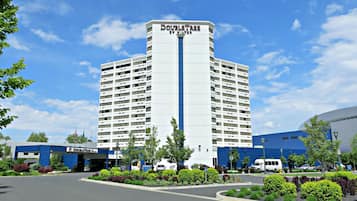 A hotel with a central tower and a flat-roofed building to the left.