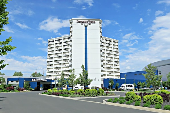 A hotel with a central tower and a flat-roofed building to the left.