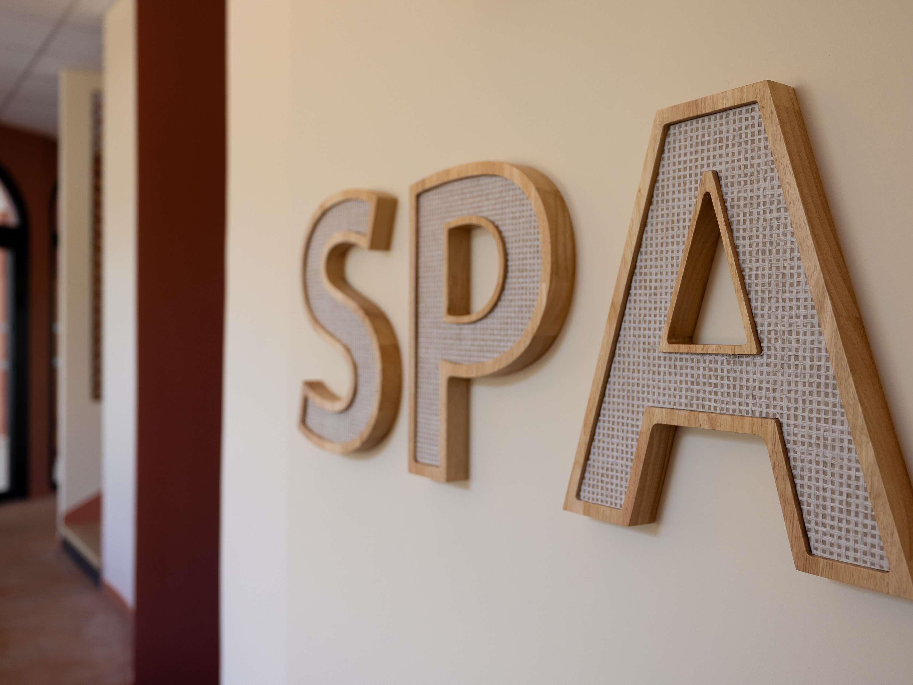 Wooden letters spelling 'SPA' on a wall.