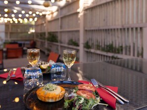 A dining table with a dessert, two glasses of white wine, and a salad. - ibis Sète Balaruc les Bains Bien-être et Spa Hotel (Balaruc-les-Bains)