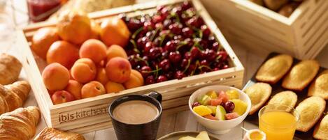 Uma mesa farta com frutas, pães e bebidas.