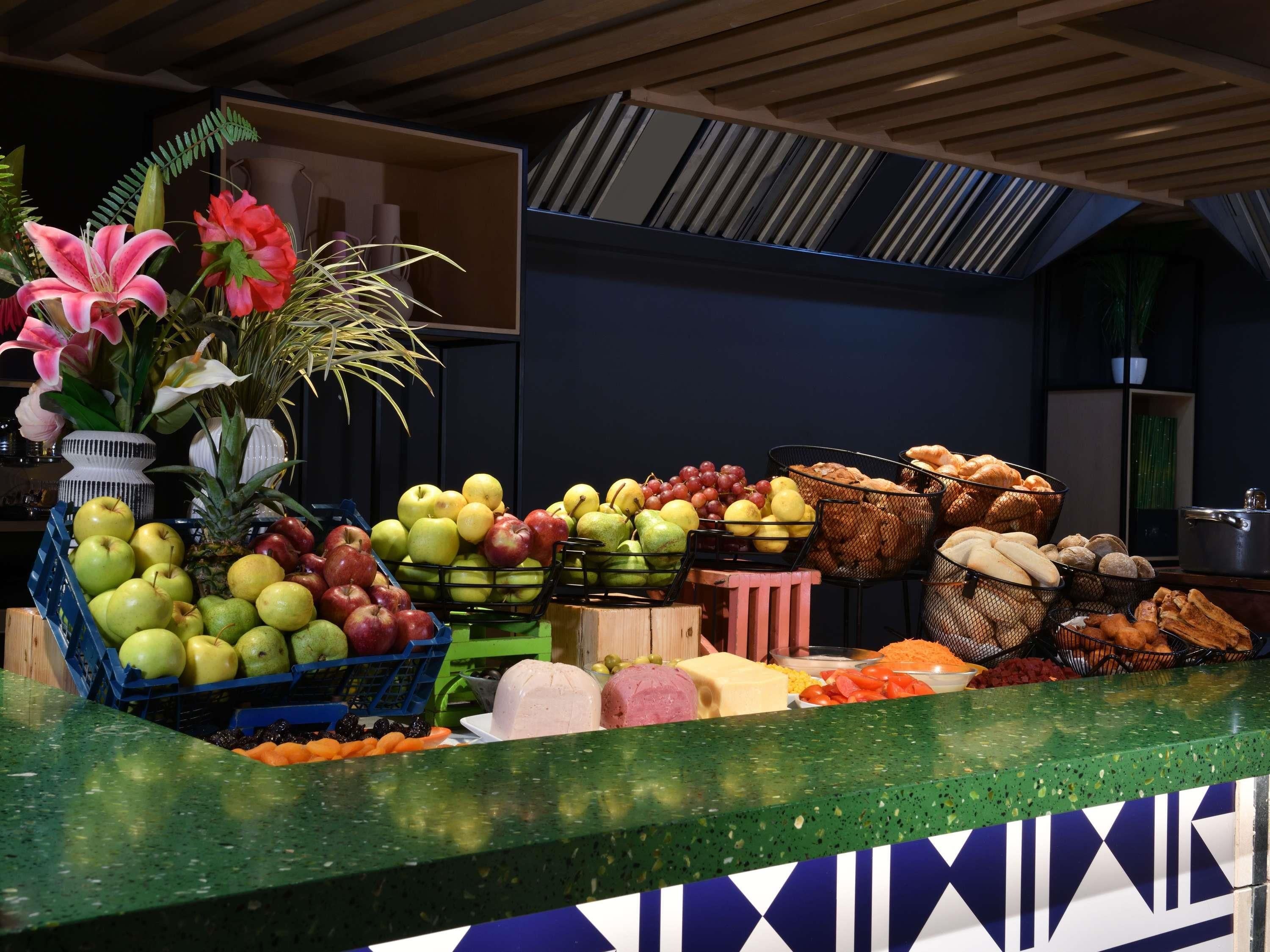 A fruit and vegetable display with a variety of produce, including apples, grapes, and carrots, arranged on a counter.