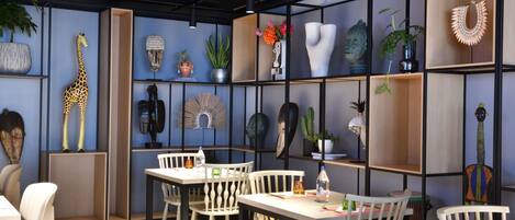 A modern interior with a dining area, shelves with decorative items, and a giraffe sculpture.