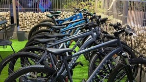 A covered outdoor area with a row of bicycles parked on artificial grass, surrounded by a fence and a mural in the background. - ibis Styles Abidjan Plateau (Abidjan)