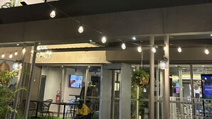 A hotel entrance with multiple banners, a covered outdoor area with seating, and a security checkpoint. - ibis Styles Abidjan Plateau (Abidjan)