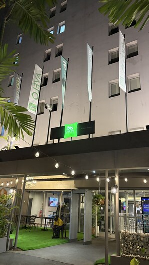 A hotel entrance with multiple banners, a covered outdoor area with seating, and a security checkpoint. - ibis Styles Abidjan Plateau (Abidjan)