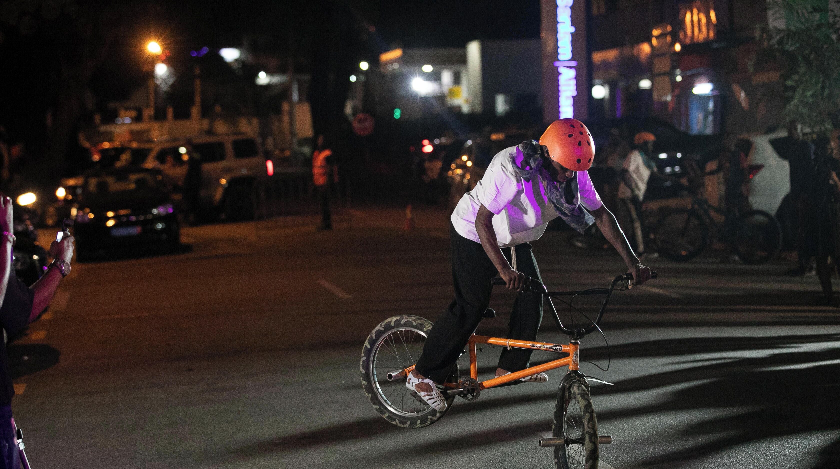 A person riding a bicycle on a street at night.