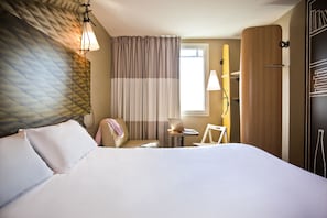 A hotel room with a bed, a desk, a chair, a lamp, and a wardrobe. - ibis Paris Place d'Italie 13th (Paris)