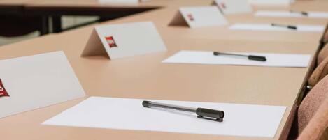 A conference room with tables, name cards, and pens.