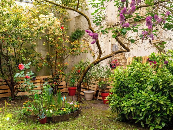 Stroll through the serene garden, surrounded by a variety of plants and flowers, and take a seat on one of the benches.