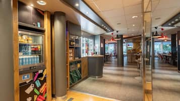 A modern interior with a vending machine, a reception desk, and a seating area.