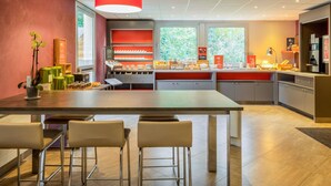 Una cocina moderna con una isla central, taburetes de bar y una lámpara colgante luminosa.