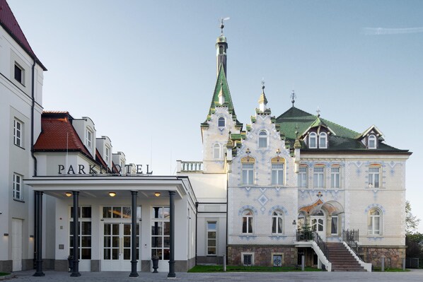 A hotel with a prominent tower, a covered entrance, and a staircase leading to the main building. - Dorint Parkhotel Meißen (Meissen)