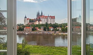 A historic building complex with multiple towers and a river in the foreground. - Dorint Parkhotel Meißen (Meissen)