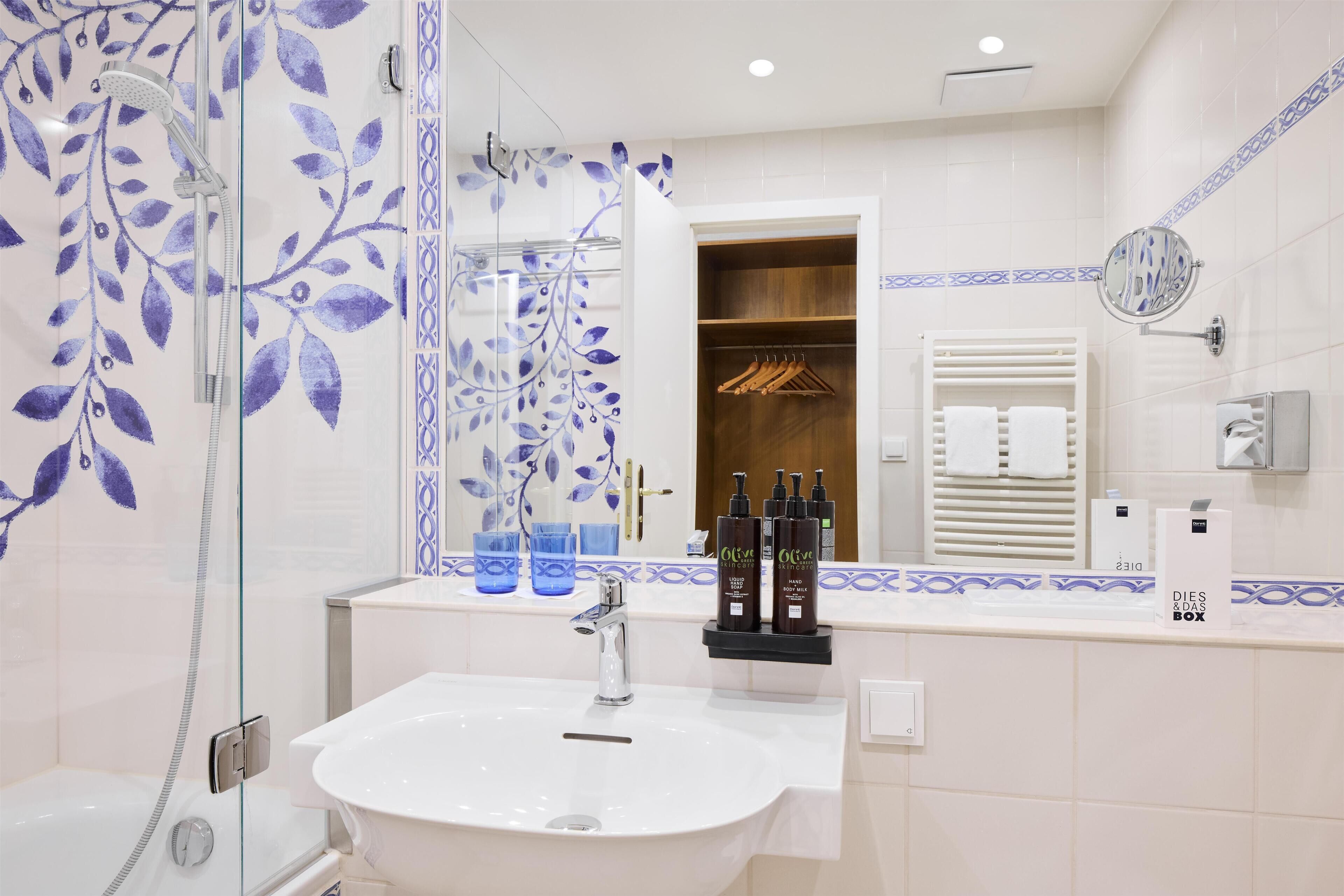 Un baño con cabina de ducha de vidrio, lavabo y espejo.