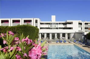 Una piscina al aire libre, tumbonas