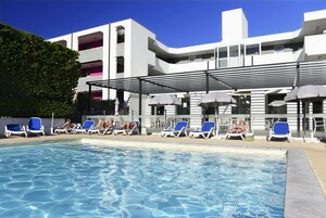 Una piscina al aire libre, sillones reclinables de piscina