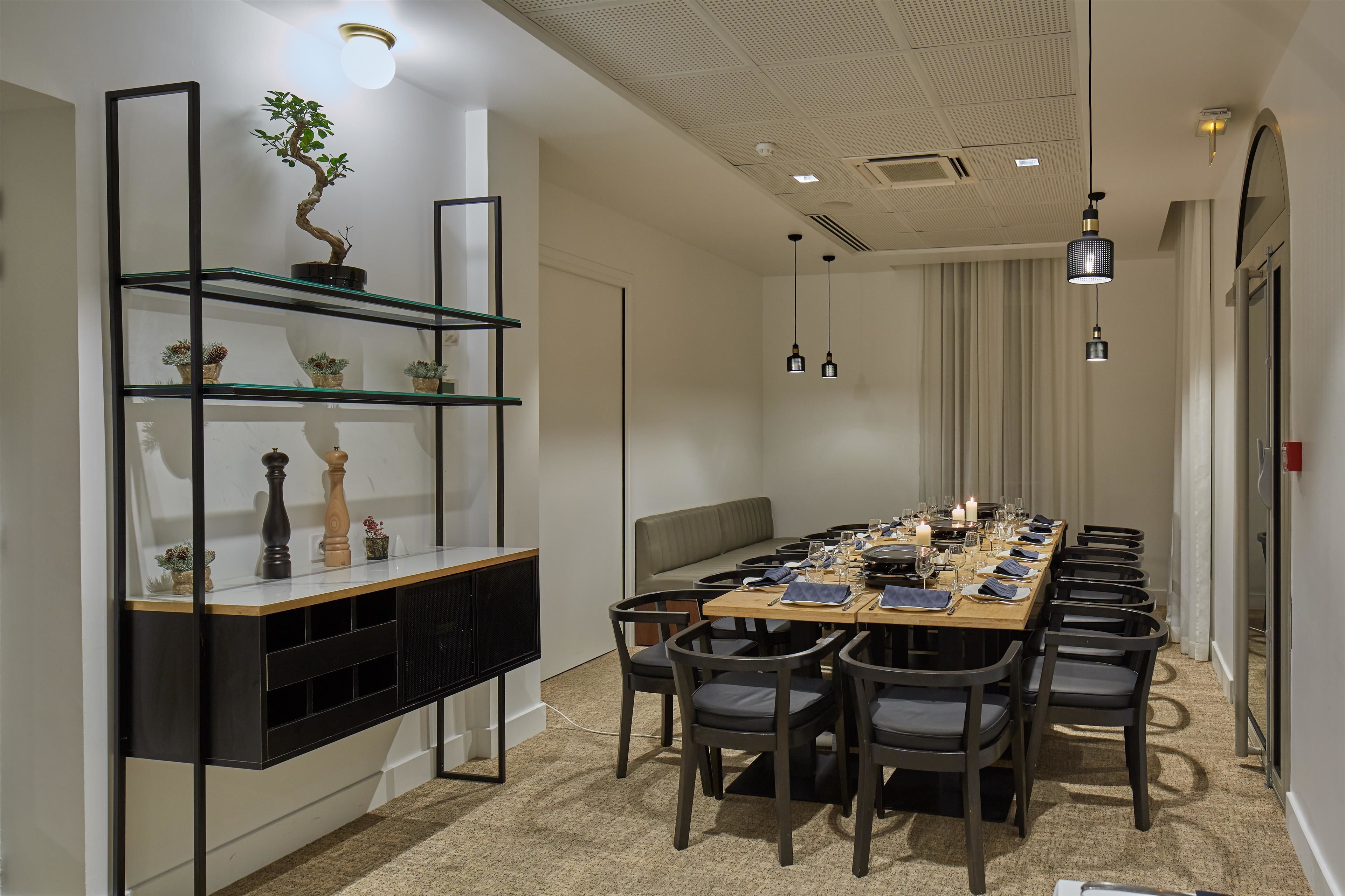 A dining area with a long table set for a meal, surrounded by chairs.