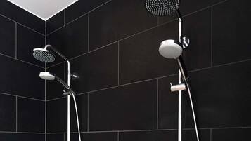 Un baño moderno con dos cabezales de ducha en la pared.