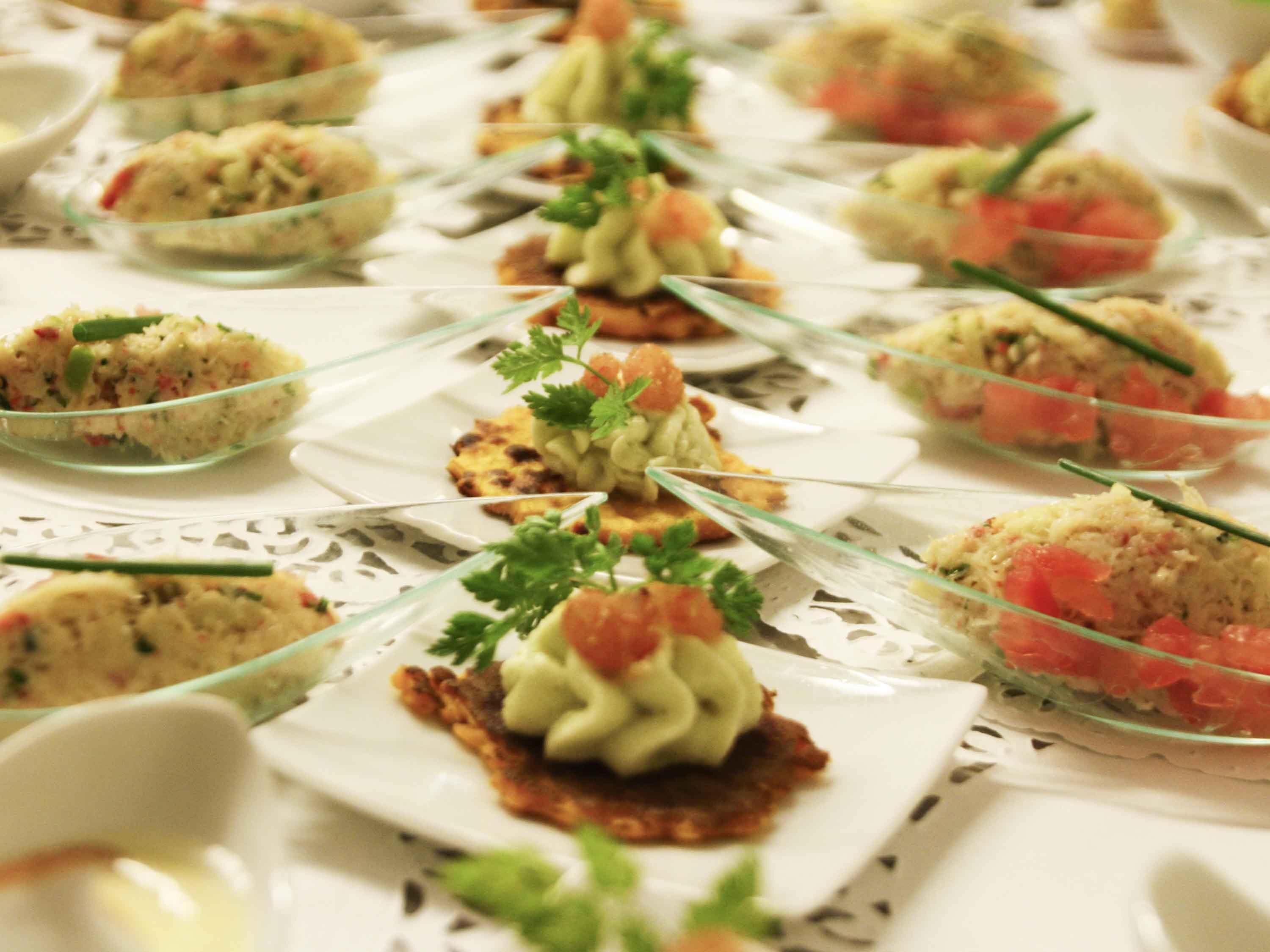 Una mesa con comida dispuesta con cuidado, que incluye aperitivos y guarniciones.