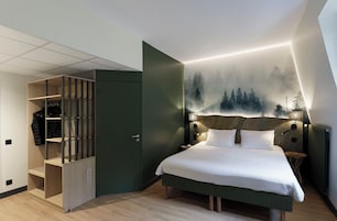 Un dormitorio con cama, armario y cabecero fijado a la pared.